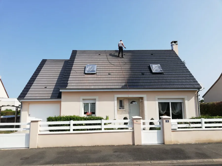 Toiture de maison en cours d’entretien, une partie déjà traitée
